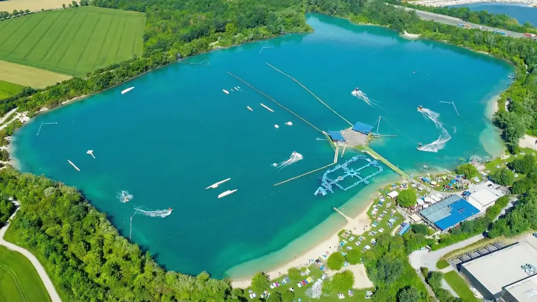 Luftaufnahme des türkisblauen Tuttenbrocksees mit den Wasserski-Seilbahnen in Beckum